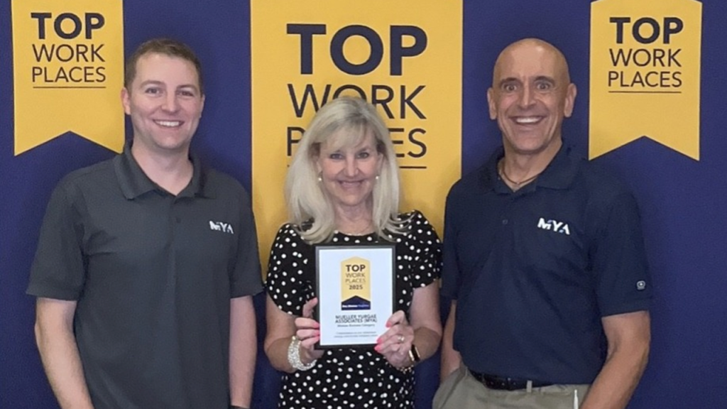 Three people holding award plaque