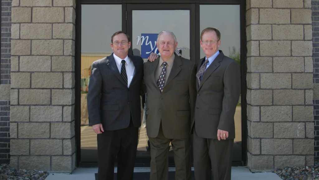 Three men in suits outside building
