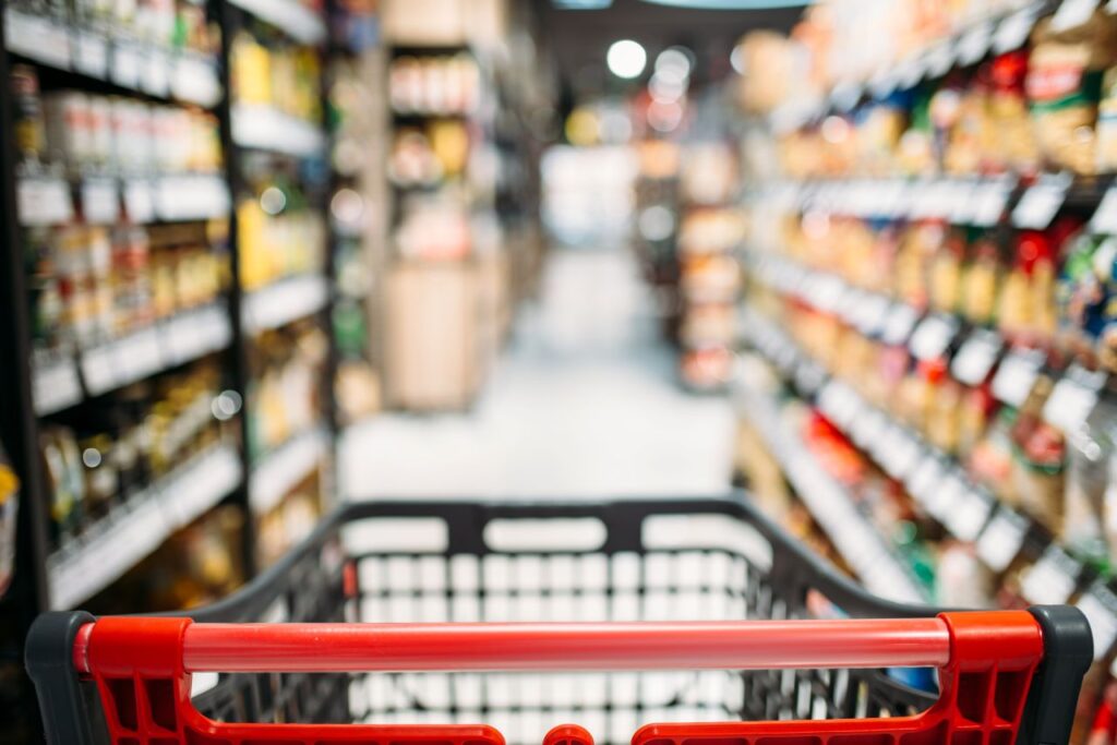 Shopping cart in grocery store aisle.