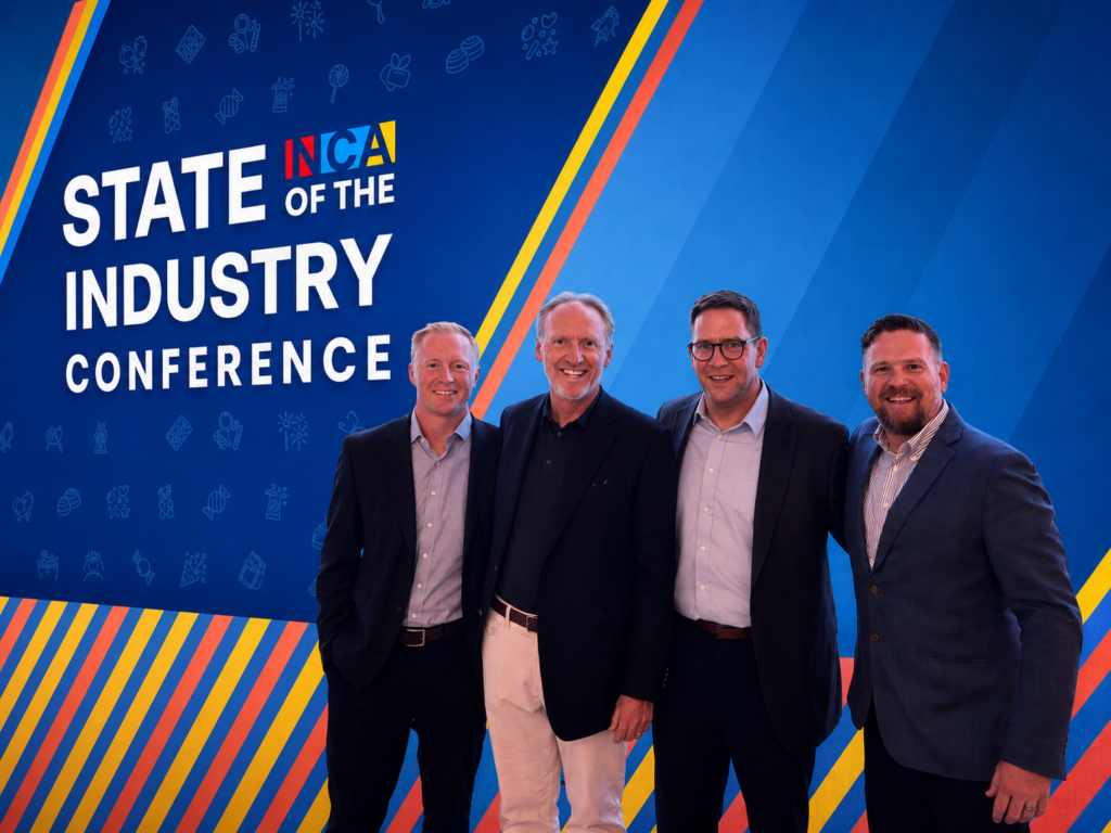 Four men at industry conference backdrop